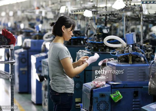 Woman works on socks that will be exported at a factory in Huaibei in China's eastern Anhui province on June 22, 2018. - Beijing on June 19 accused...