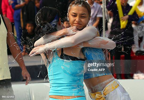 Two Chinese women wrestle in a mud pool during an international women's mud wrestling contest held in Haikou, south China's Hainan island on March...