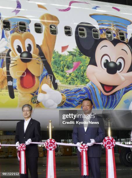 Japan Airlines Co. President Yuji Akasaka and Kyoichiro Uenishi, president of Oriental Land Co., which operates Tokyo Disney Resort, cut the ribbon...