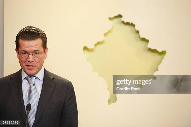 German Defense Minister Karl-Theodor zu Guttenberg speaks in front of a Kosovan relief during a press conference on March 29, 2010 in Pristina,...