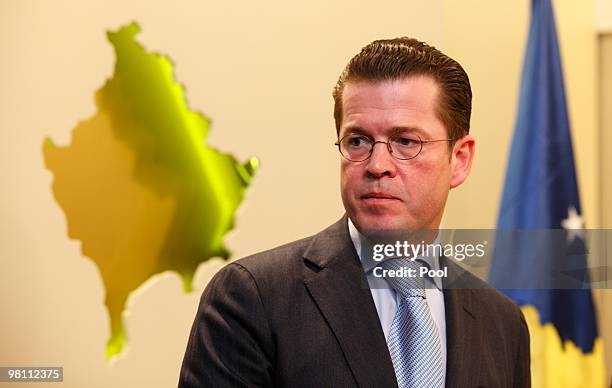 German Defense Minister Karl-Theodor zu Guttenberg stands in front of a Kosovan relief during a press conference on March 29, 2010 in Pristina,...