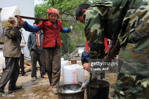 Chinese villagers collect water from a military water truck in the village of Qujing, in southwest China's Yunnan province on March 28, 2010....