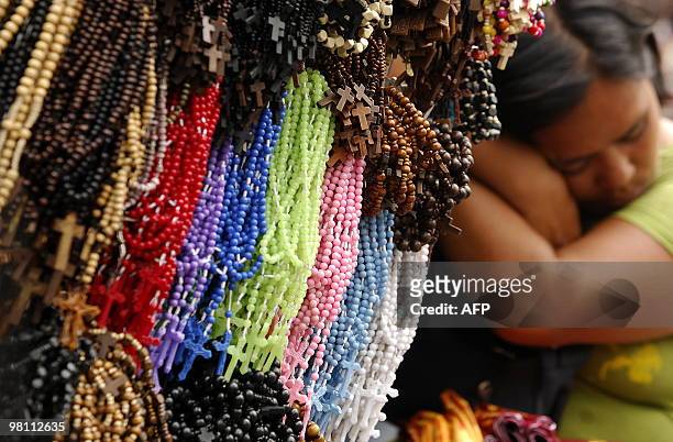 Filipino vendor sleeps next to her Christian rosaries for sale near the Quiapo church in Manila on March 29, 2010. The Philippines is Asia's bastion...