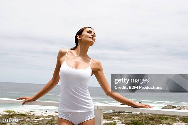 young woman on balcony - ballustrade stockfoto's en -beelden