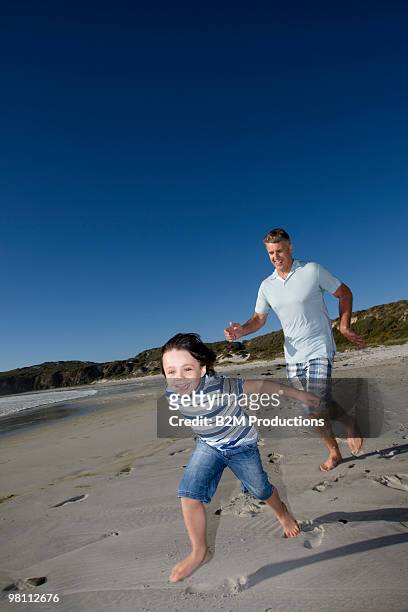 grandfather and boy (4-5) running on beach - 45 49 år bildbanksfoton och bilder