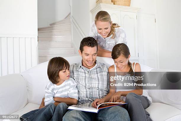family reading a book - woman smiling facing down stock pictures, royalty-free photos & images