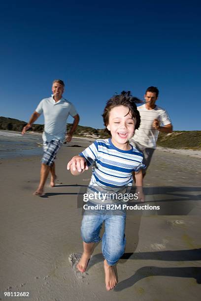 grandfather, father and son (4-5) running on beach - 45 49 år bildbanksfoton och bilder