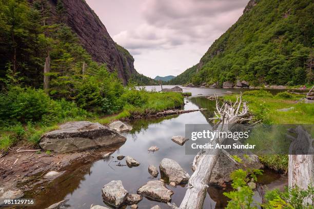 moody sky over avalanche lake and green mountains, lake placid, montana, usa - lake placid stock pictures, royalty-free photos & images