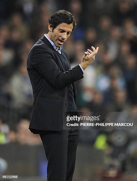 Atletico Madrid's coach Quique Sanchez Flores gestures as they play against Real Madrid during their Spanish League football match at Santiago...