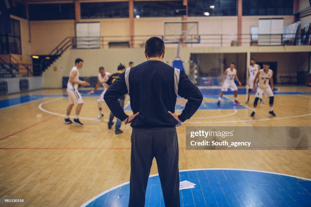 Coach watching basketball training