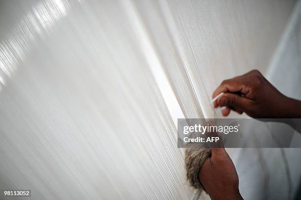 An Nepali woman weaves a carpet at a workshop in Kathmandu on March 26, 2010. Carpets remain one of the main exports of the Himalayan nation where...