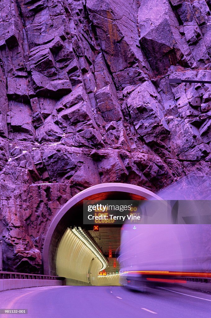 Lorry entering tunnel in cliff-face long exposue with violet cast