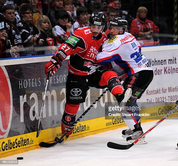 Ivan Ciernik of Cologne challenges for the puck with Prestin Ryan of Ingolstadt during the DEL playoff match between Koelner Haie and ERC Ingolstadt...