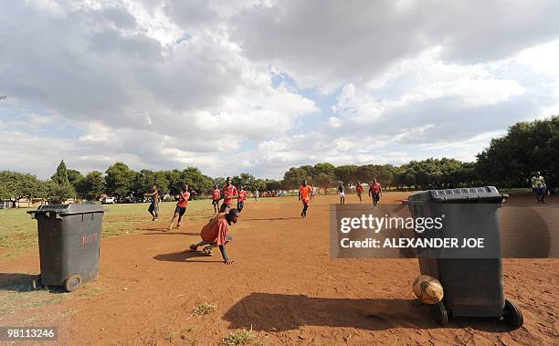 Group of men paly a match with trash cans used as goals and orange police road sings as lines in Soweto on March 28, 2010. The Fifa 2010 World Cup...