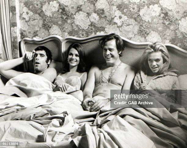 American actors Elliott Gould, Natalie Wood, Robert Culp and Dyan Cannon sit in bed together in a promotional still from the film, 'Bob & Carol & Ted...