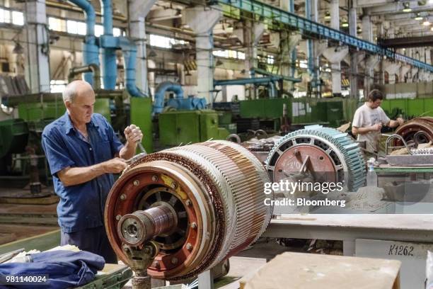 Workers fit electricity generating components to the rotors of generators at the Electrotyazhmash plant in Kharkiv, Ukraine, on Thursday, June 21,...