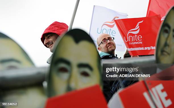 Demonstrator is pictured through placards depicting Willie Walsh, Chief Executive of British Airways, at a picket line of British Airways cabin crew...