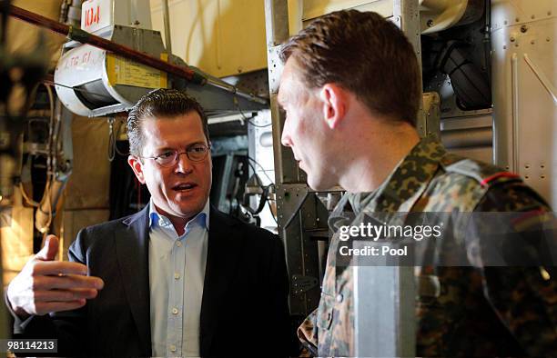 German Defense Minister Karl-Theodor zu Guttenberg talks to a Bundeswehr soldier during his flight from Berlin to Priststina on March 29, 2010. Zu...