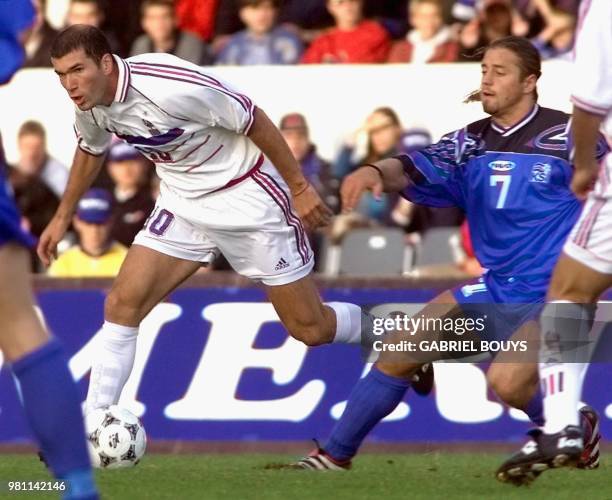 Le milieu de terrain français Zinedine Zidane est aux prises avec le milieu de terrain islandais Helgi Kolvidsson, le 05 septembre à Reykjavic, lors...