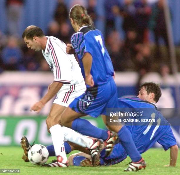 Le milieu de terrain français Zinedine Zidane est aux prises avec le milieu de terrain Helgi Kolvidsson et l'attaquant Rikhardur Dadason, lors de la...