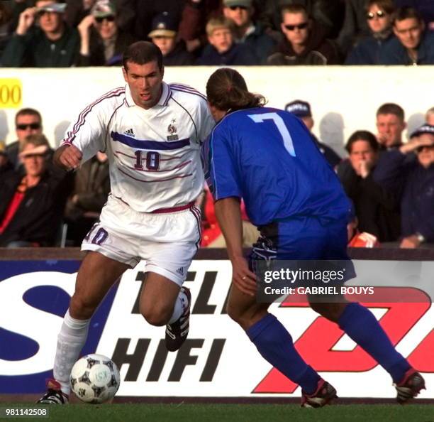 Le milieu de terrain français Zinédine Zidane est aux prises avec le milieu de terrain islandais Helgi Kolvidsson, le 05 septembre à Reykjavic, lors...