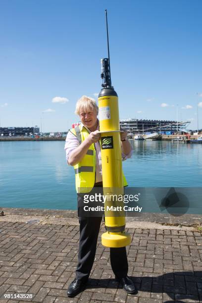 Foreign Secretary Boris Johnson holds up a demo Met Office Argo float used for measuring ocean temperatures and salinity, on a visit to National...