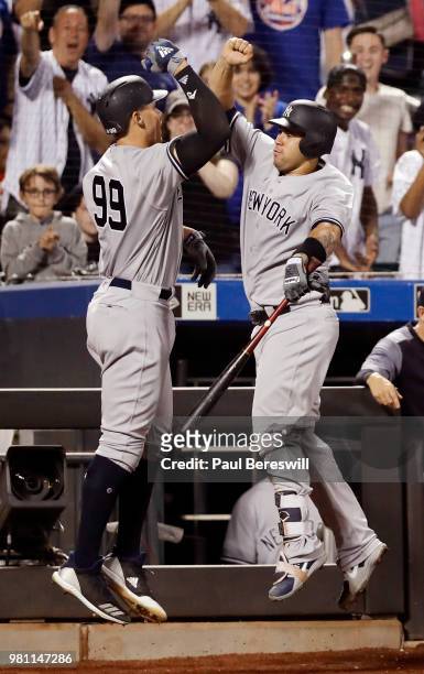 Aaron Judge of the New York Yankees celebrates with teammate Gary Sanchez as fans cheer in the background after Judge hit a home run in the 8th...