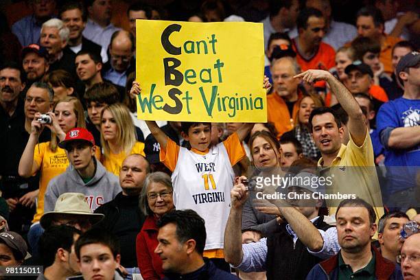 Fan of the West Virginia Mountaineers holds up a sign which reads "Can't Beat West Virginia" in reference to the game being broadcast on the CBS...