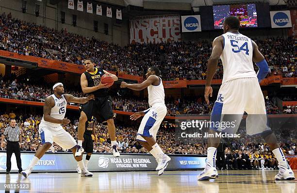Joe Mazzulla of the West Virginia Mountaineers looks to pass the ball against DeMarcus Cousins, John Wall and Patrick Patterson of the Kentucky...