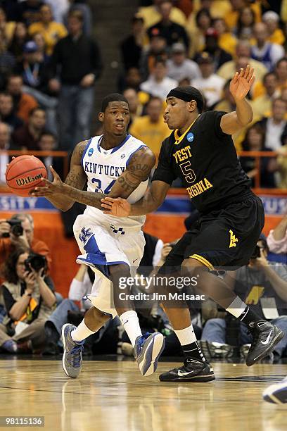 DeAndre Liggins of the Kentucky Wildcats drives against Kevin Jones of the West Virginia Mountaineers during the east regional final of the 2010 NCAA...