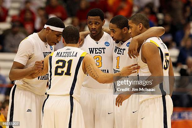 Kevin Jones, Joe Mazzulla, Devin Ebanks, Da'Sean Butler and Wellington Smith of the West Virginia Mountaineers talk in a huddle against the...