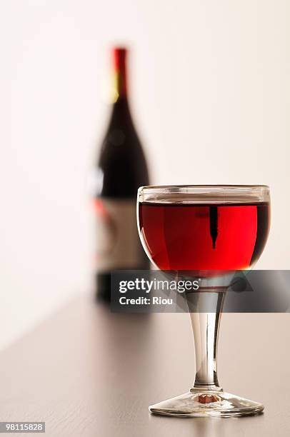 glass and bottle of red wine - bouteille en verre stockfoto's en -beelden