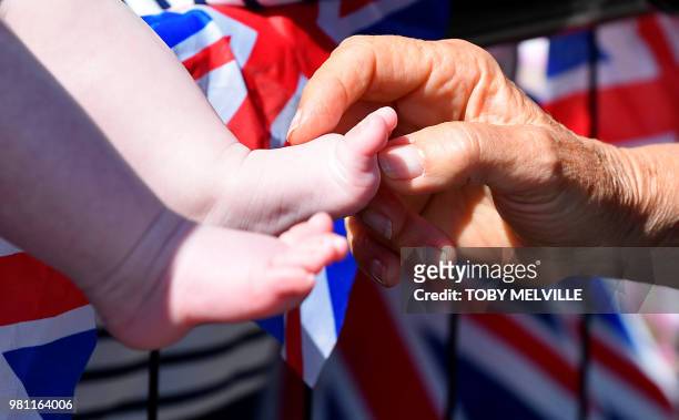 Britain's Camilla, Duchess of Cornwall tickles a baby's foot as she greets well-wishers during a visit to Salisbury in south-west England on June 22,...