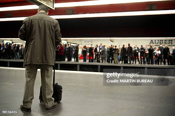 People wait for a train on a platform on March 23, 2010 at the Auber suburban train station in Paris, as French public sector workers, including...