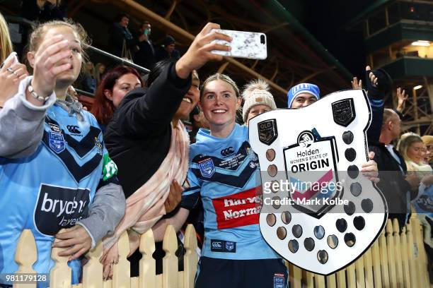 Maddison Studdon of the Blues holds the shield as she celebrates victory with the crowd during the Women's State of Origin match between New South...