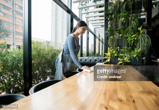 waitress setting the table at a restaurant - restaurant cleaning stock pictures, royalty-free photos & images