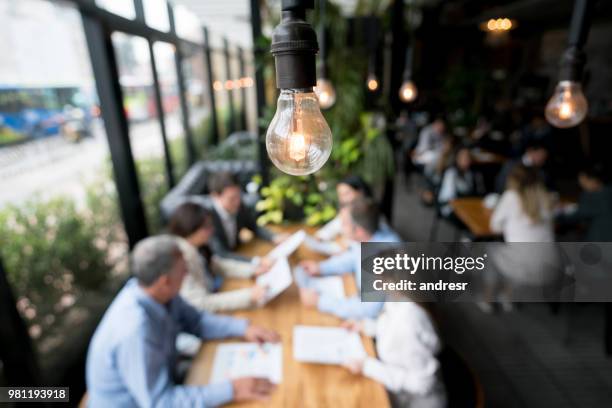 creative business team in a meeting at a restaurant - lightbulbs coffee shop stock pictures, royalty-free photos & images