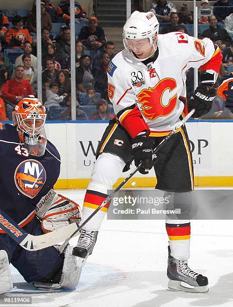 Forward David Moss of the Calgary Flames tries to tip the puck in front of goalie Martin Biron of the New York Islanders during an NHL game at the...