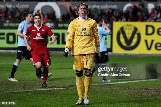 Goalkeeper Tobias Sippel of Kaiserslautern celebrates with team mate Florian Dick after parrying a penalty by Alexander Ludwig of Muenchen during the...