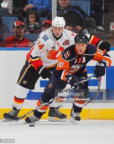 Craig Conroy of the Calgary Flames looks on as Richard Park of the New York Islanders skates away with the puck during an NHL game at the Nassau...