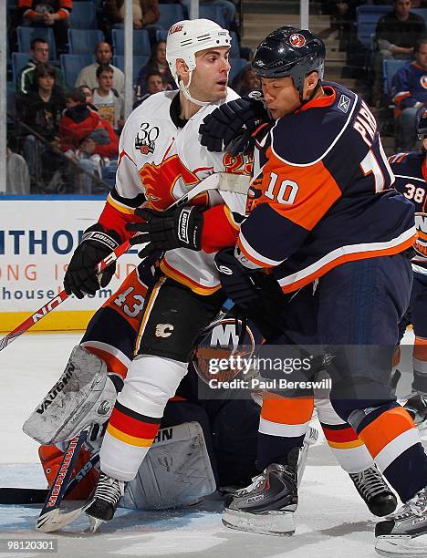 Eric Nystrom of the Calgary Flames is checked by Richard Park of the New York Islanders during an NHL game at the Nassau Coliseum on March 25, 2010...