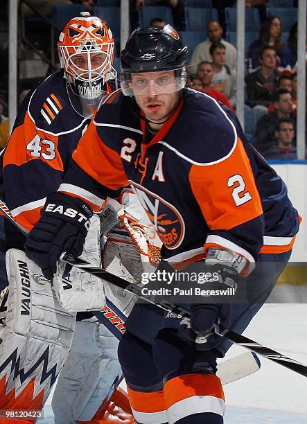 Goalie Martin Biron and defenseman Mark Streit of the New York Islanders eye the puck during action in an NHL game against the Calgary Flames at the...