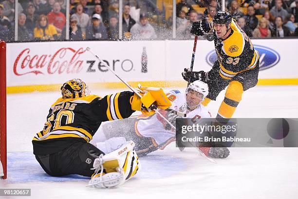 Jarome Iginla of the Calgary Flames falls on the ice in from of Tim Thomas of the Boston Bruins at the TD Garden on March 27, 2010 in Boston,...