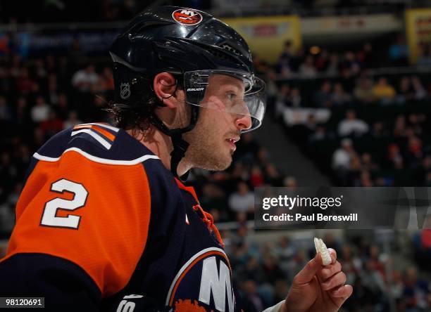 Defenseman Mark Streit of the New York Islanders holds his mouthpiece during a break in play in an NHL game against the Calgary Flames at the Nassau...