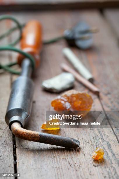 old soldering iron with rosin and solder on wooden table - resina foto e immagini stock