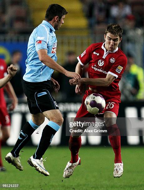 Erik Jendrisek of Kaiserslautern is challenged by Mate Ghvinianidze of Muenchen during the Second Bundesliga match between 1. FC Kaiserslautern and...