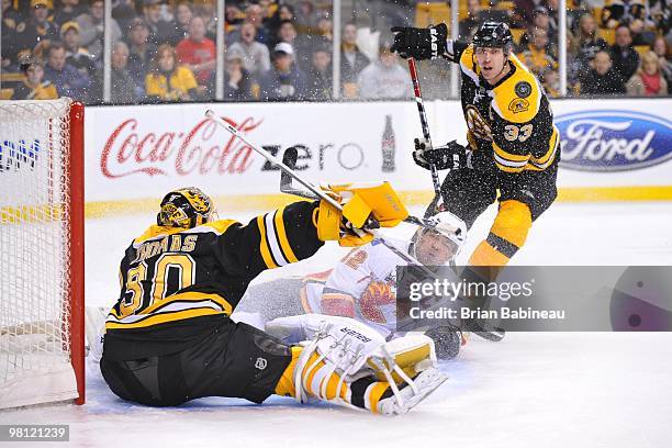 Tim Thomas of the Boston Bruins makes a save against Jarome Iginla of the Calgary Flames at the TD Garden on March 27, 2010 in Boston, Massachusetts.