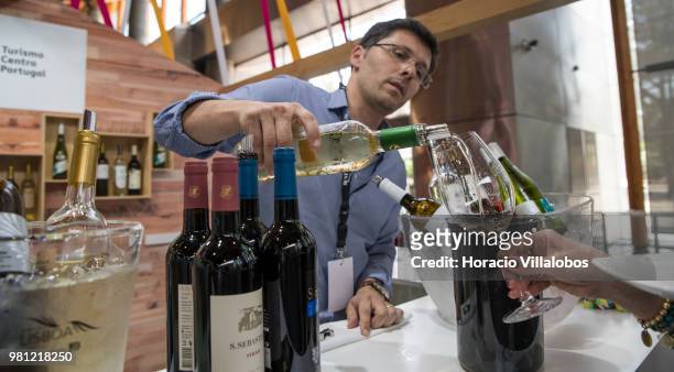 Server pours Centro region white wine at Turismo de Centro stand during lunch break during the final day of MUST - Fermenting Ideas - Wine Summit...