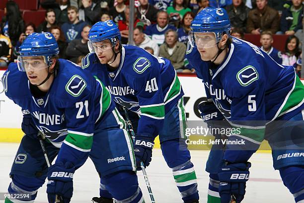 Mason Raymond, Michael Grabner and Christian Ehrhoff of the Vancouver Canucks wait for a face-off during their game against the Anaheim Ducks at...