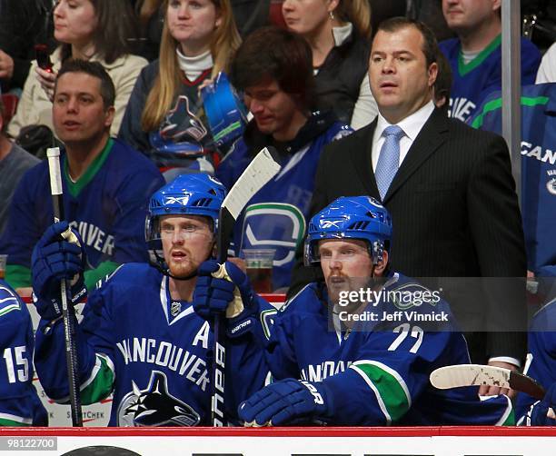 Henrik Sedin, Daniel Sedin and Head coach Alain Vigneault of the Vancouver Canucks look on from the bench during their game against the Anaheim Ducks...